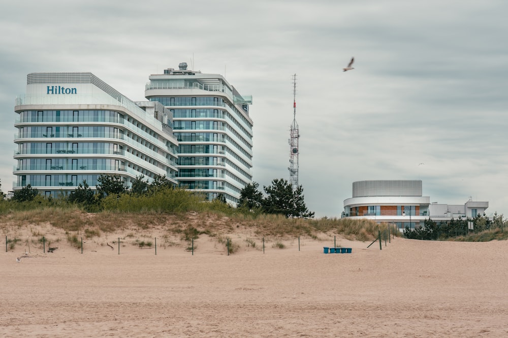 a building on a beach with a bird flying by