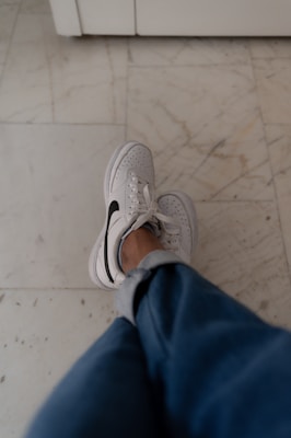a person standing on a tile floor with their feet up