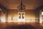 an empty room with a chandelier and a chair