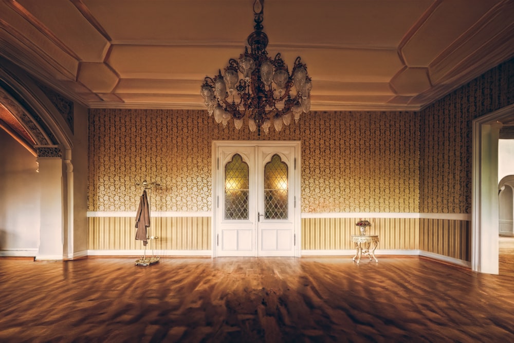 an empty room with a chandelier and a chair