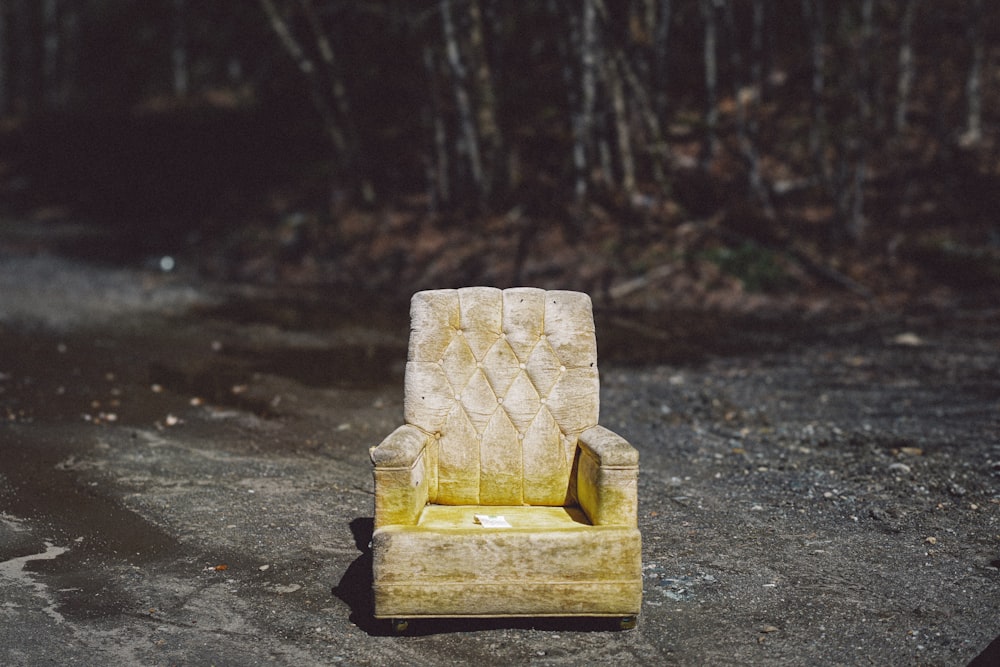 a yellow chair sitting on top of a cement ground
