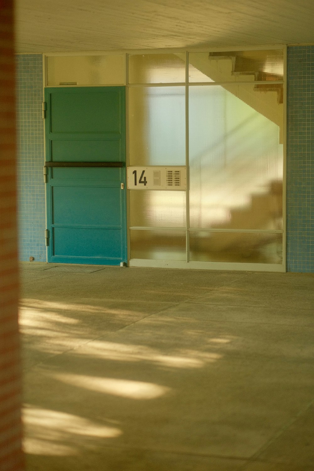 an empty room with a blue door and a red brick wall