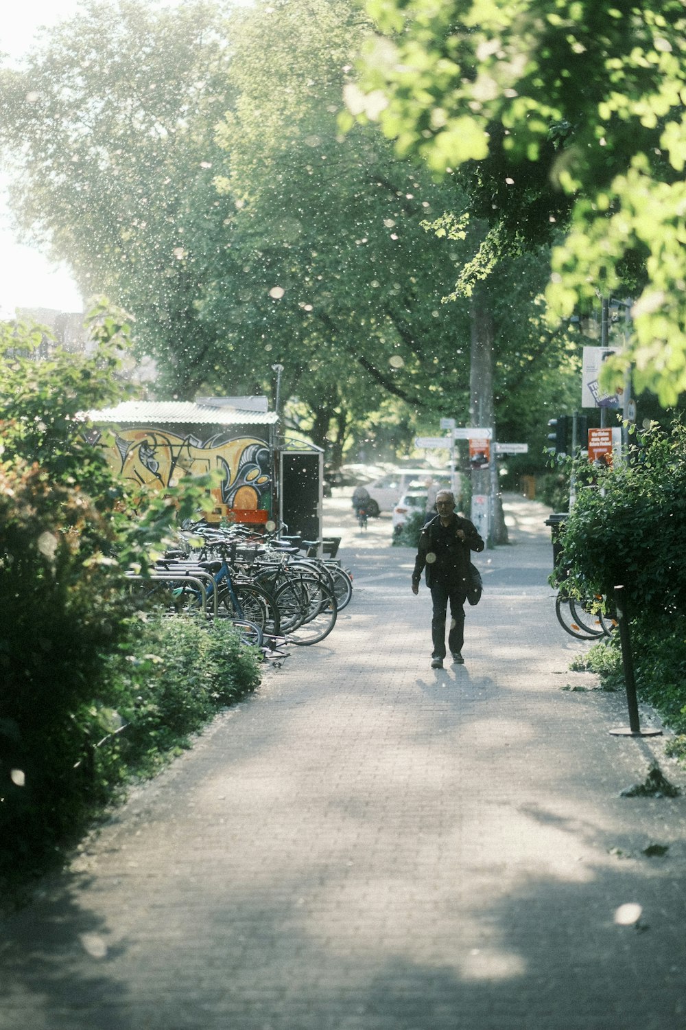 a person walking down a street next to parked bicycles