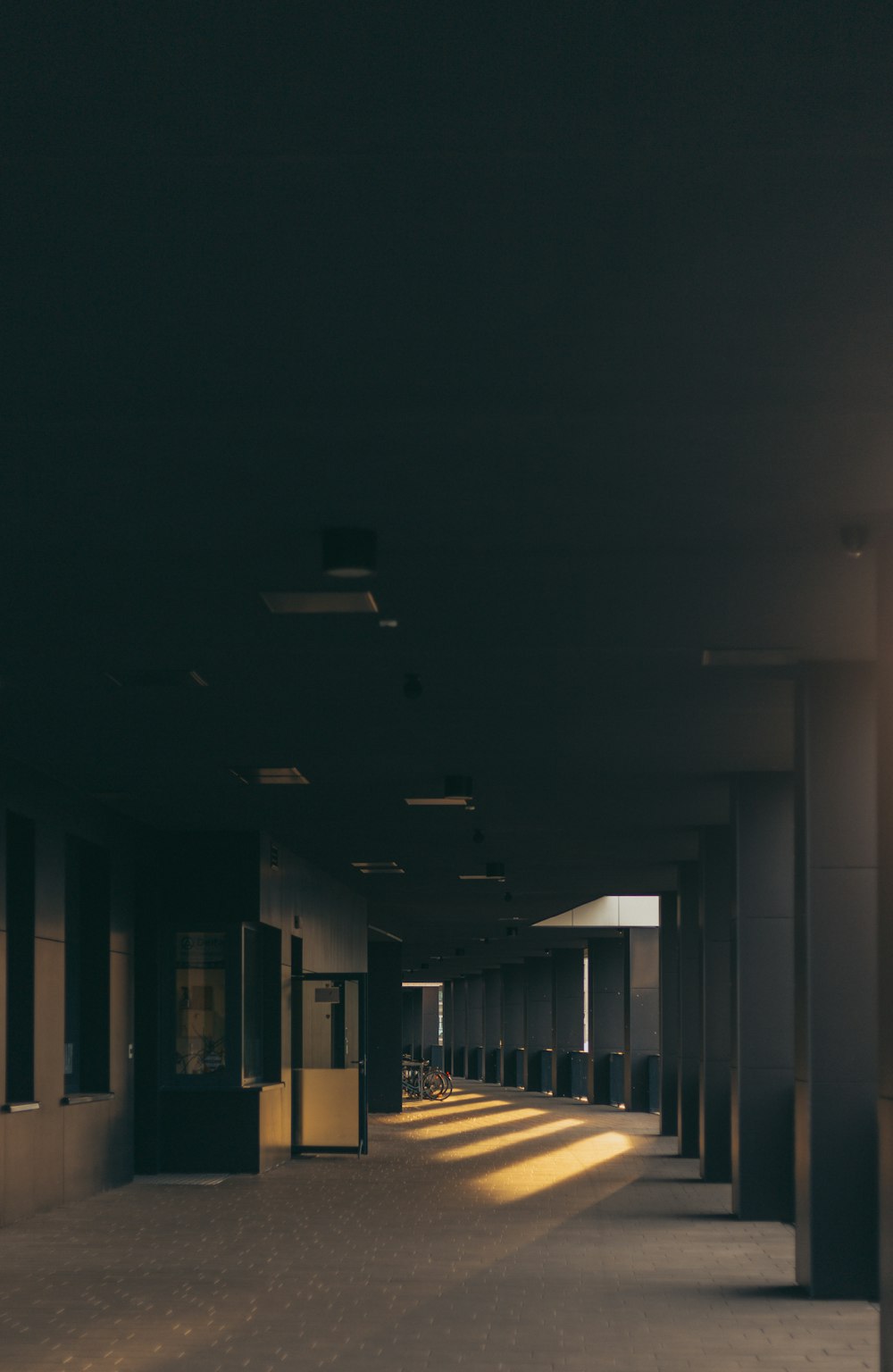 an empty hallway in a building with a clock on the wall