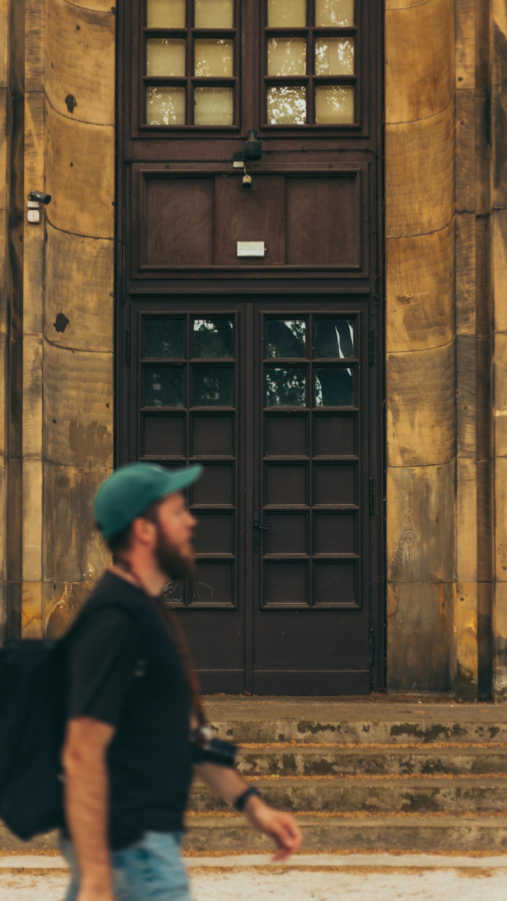 a man with a backpack walking in front of a building