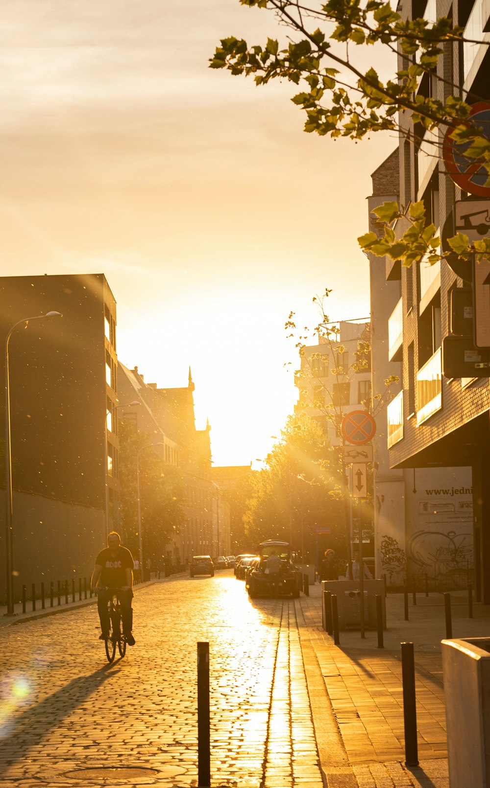 a man riding a bike down a street next to tall buildings