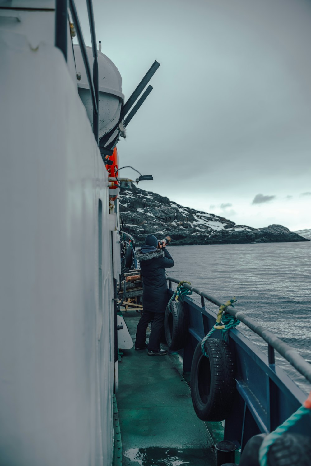 a man standing on a boat next to a body of water