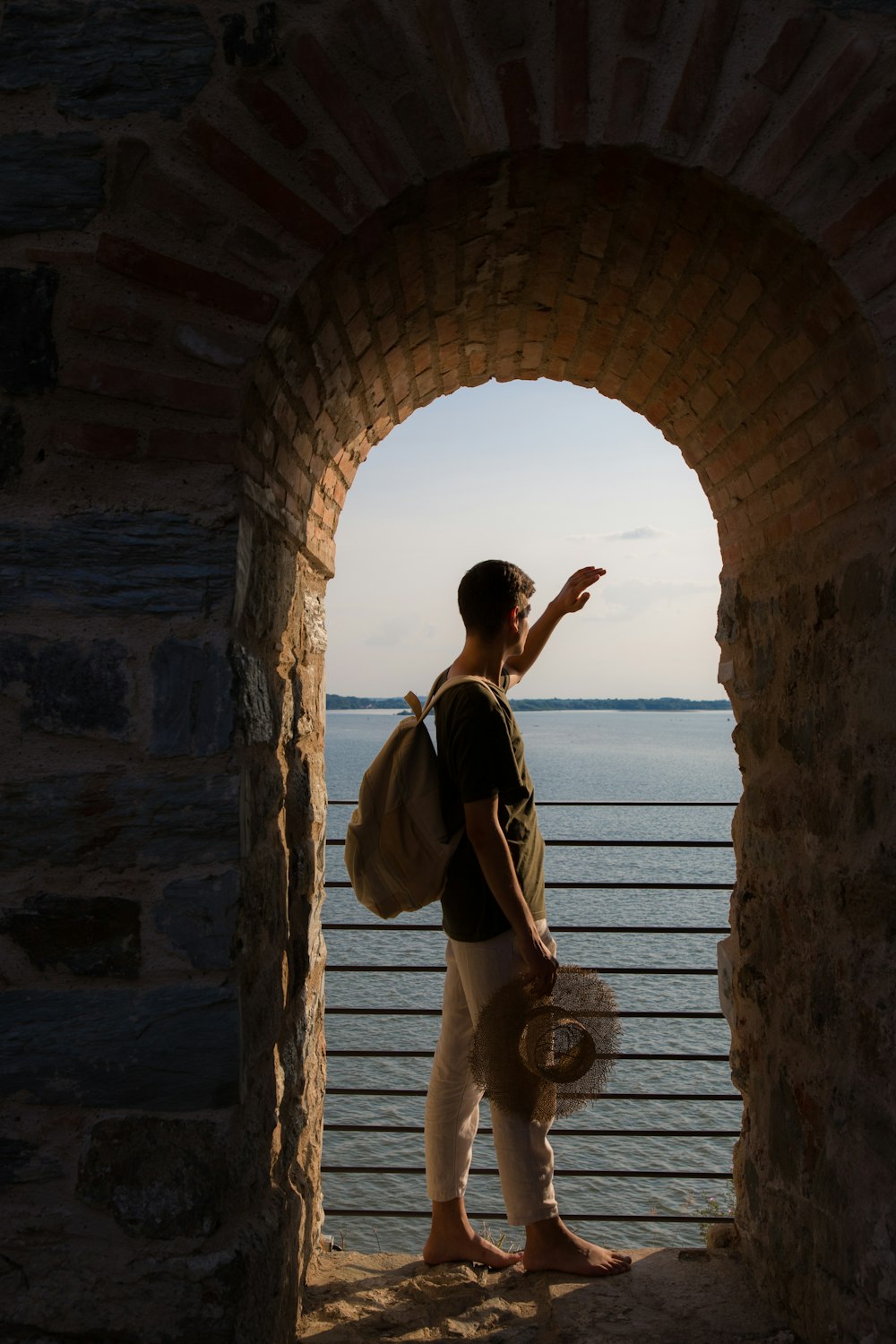 a man with a backpack is looking out at the water