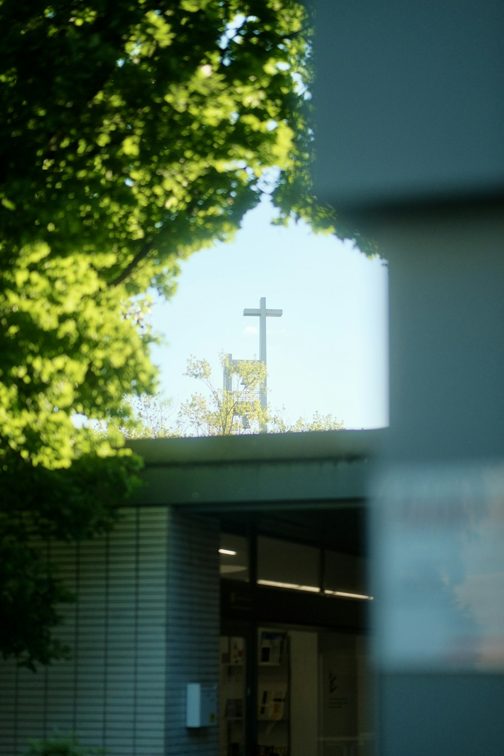 a cross on top of a building next to a tree
