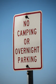 a no camping or overnight parking sign on a pole