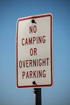 a no camping or overnight parking sign on a pole