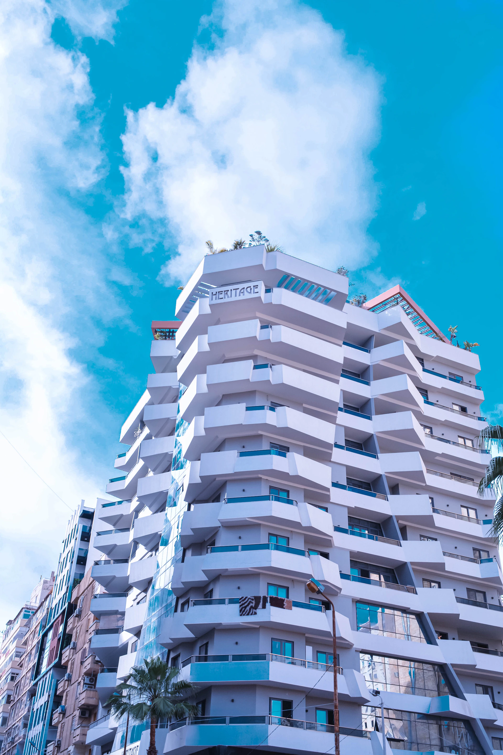 a tall white building with balconies on top of it