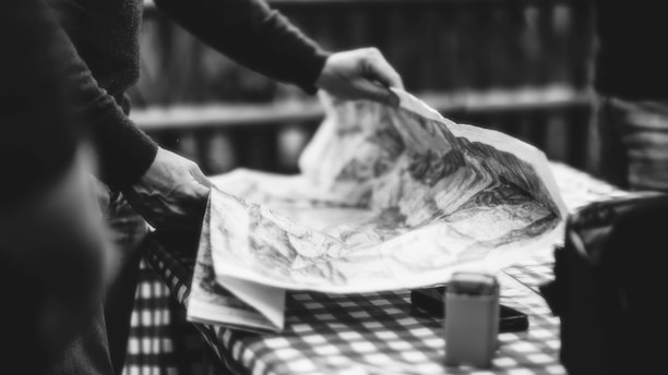 a black and white photo of a person holding a map