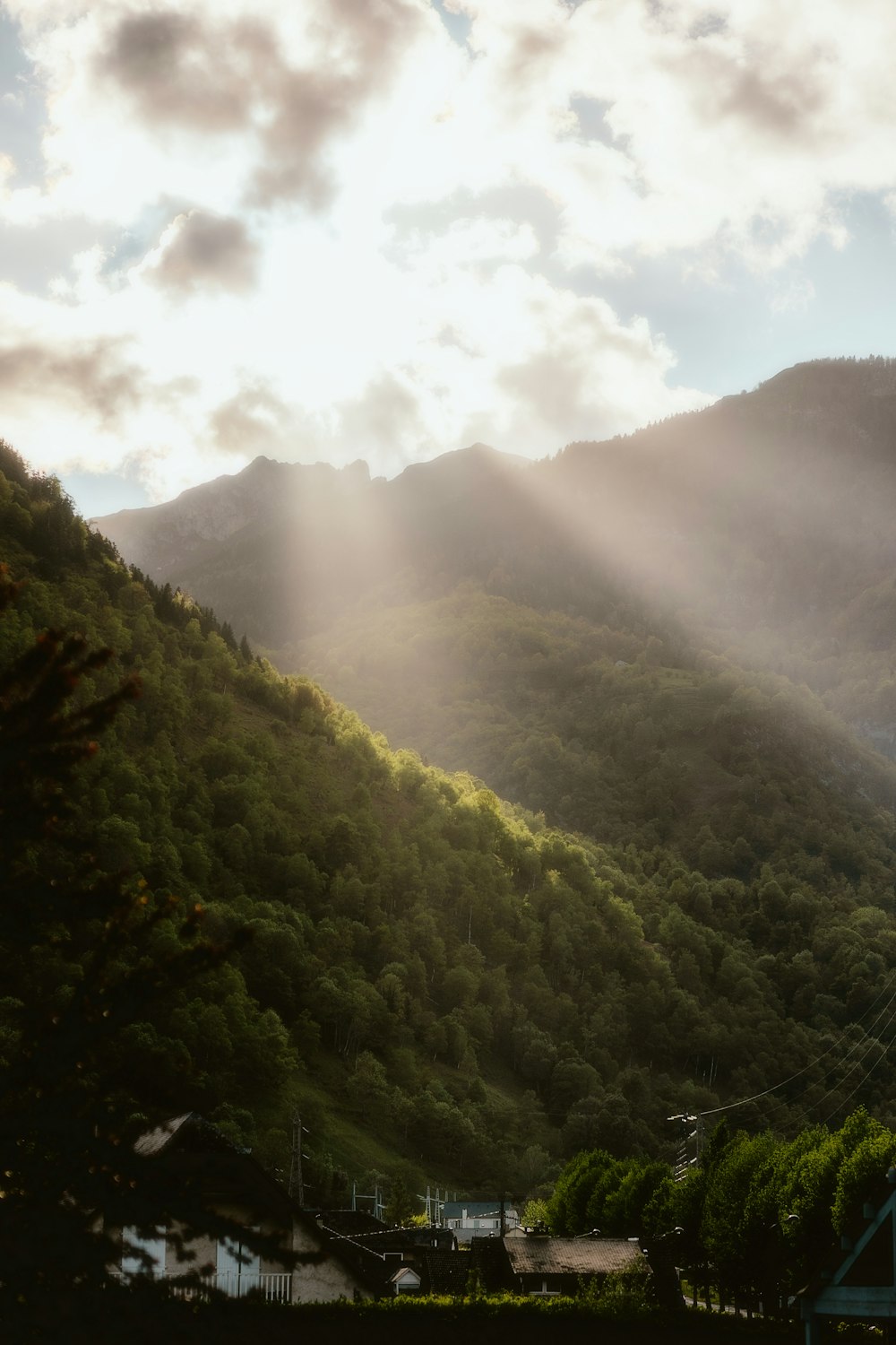 the sun is shining through the clouds over the mountains