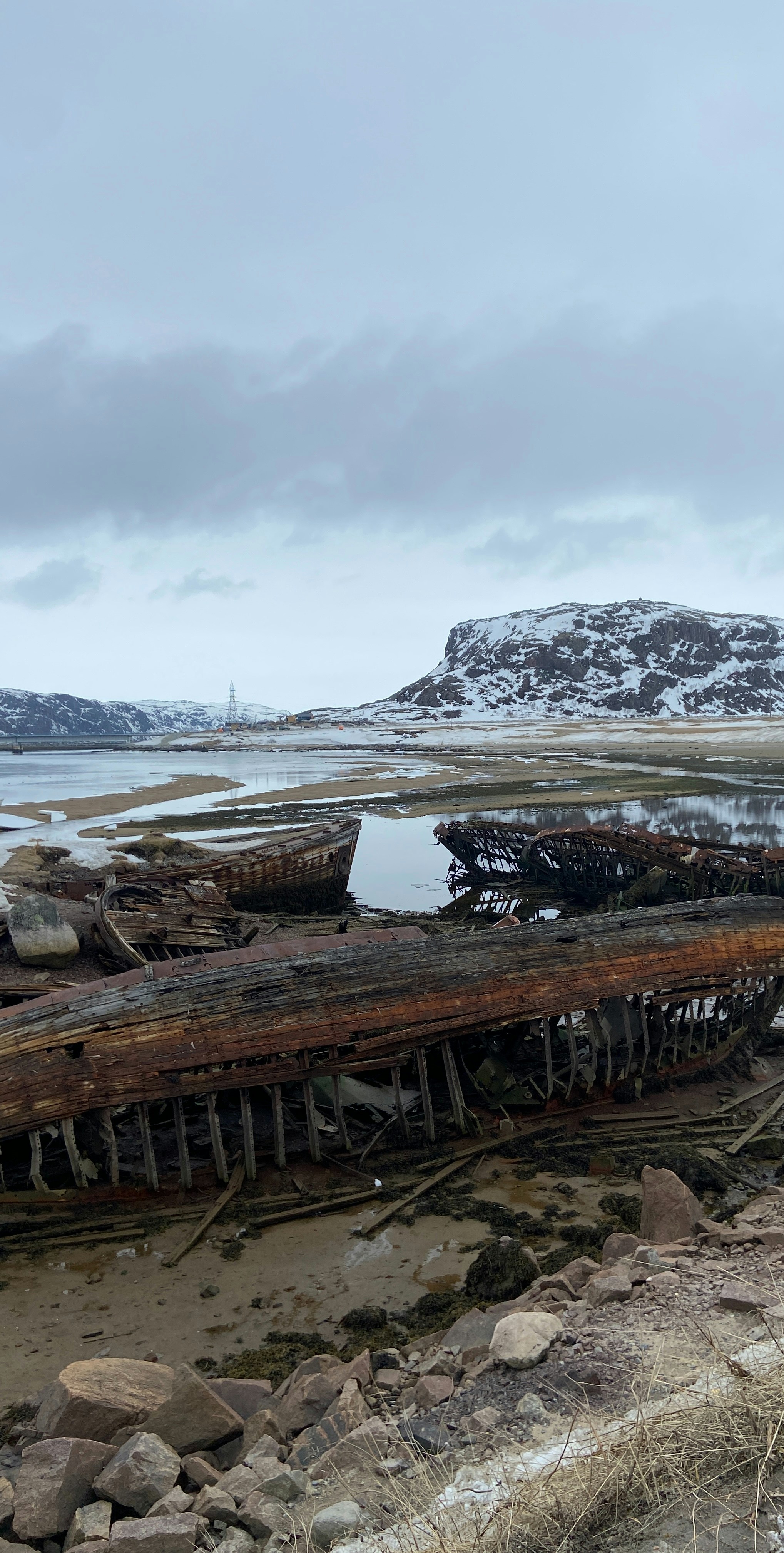 an old boat sitting on top of a sandy beach