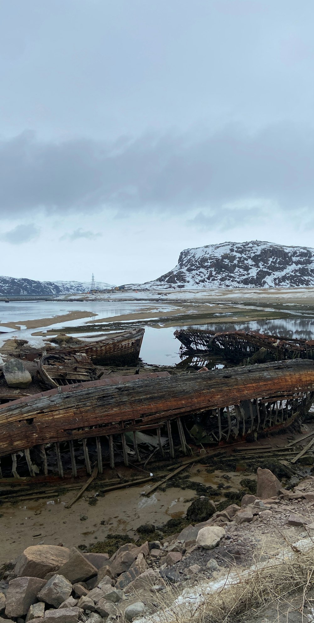 an old boat sitting on top of a sandy beach