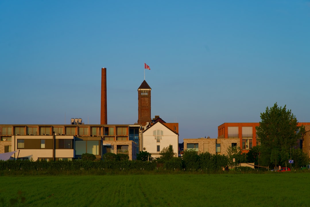a building with a clock tower in the middle of a field,