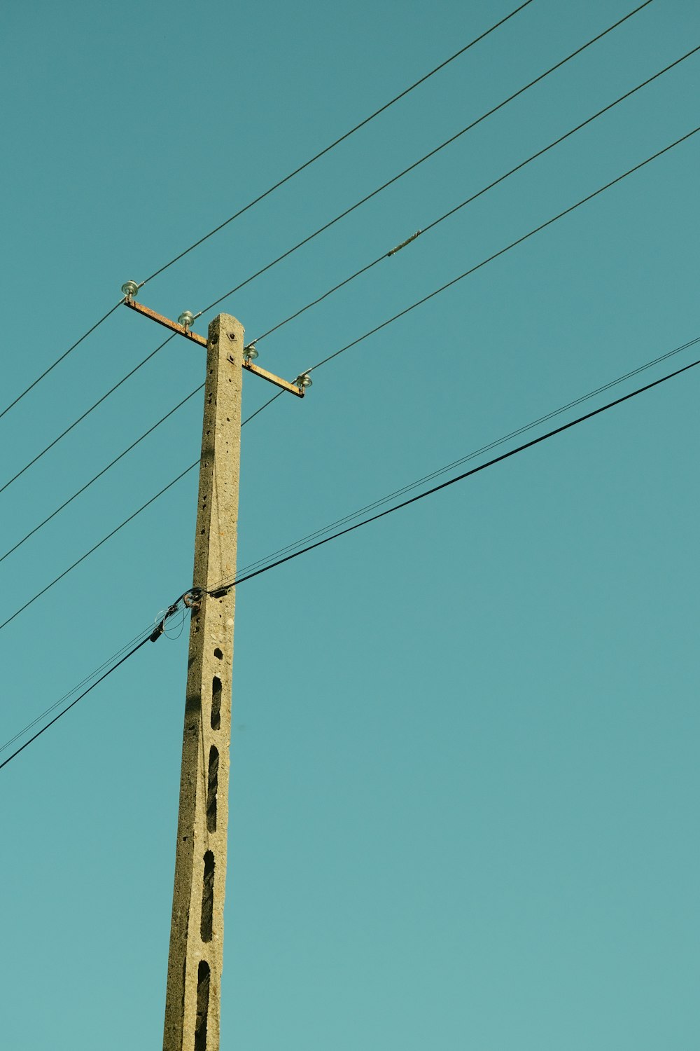a tall wooden pole with power lines above it