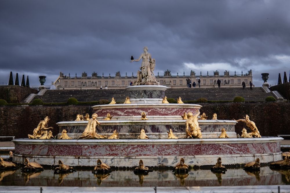 a fountain in front of a building with a statue on top of it