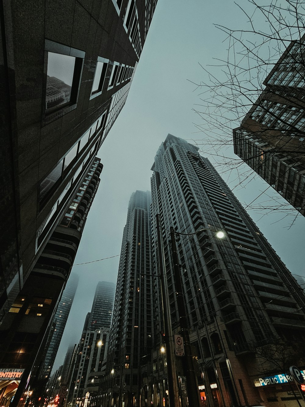 looking up at tall buildings in a city at night