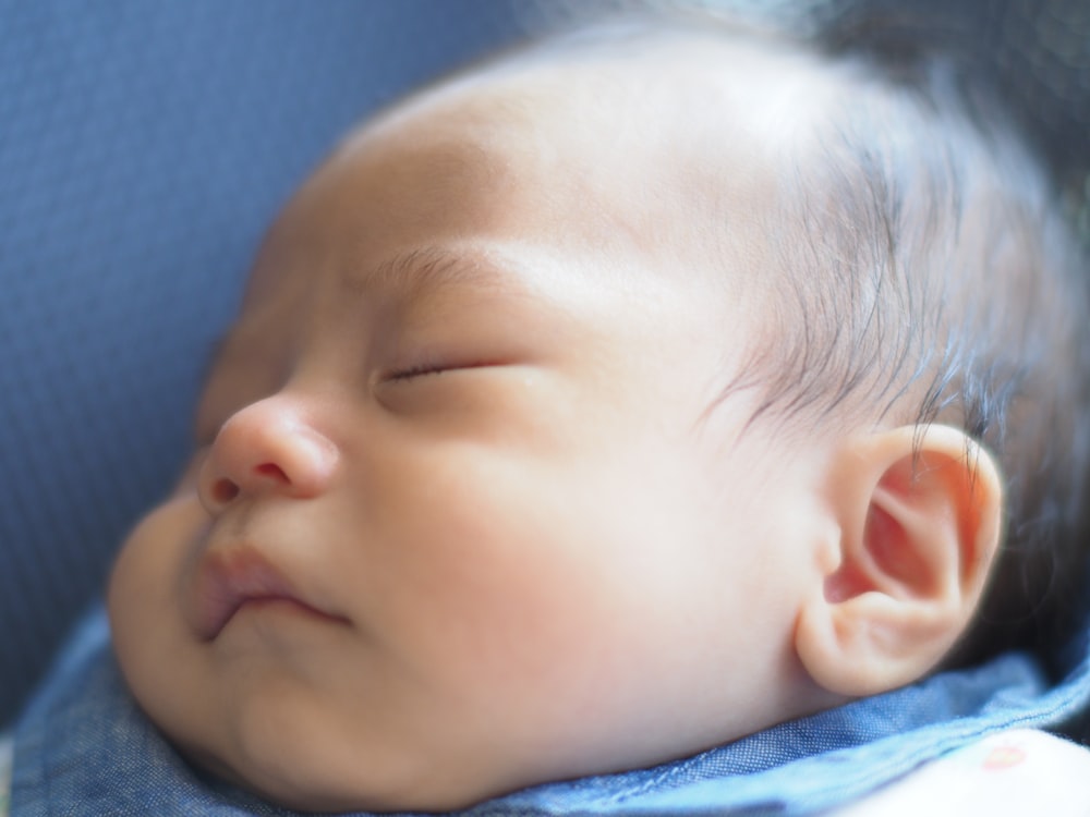 a close up of a baby sleeping on a blanket