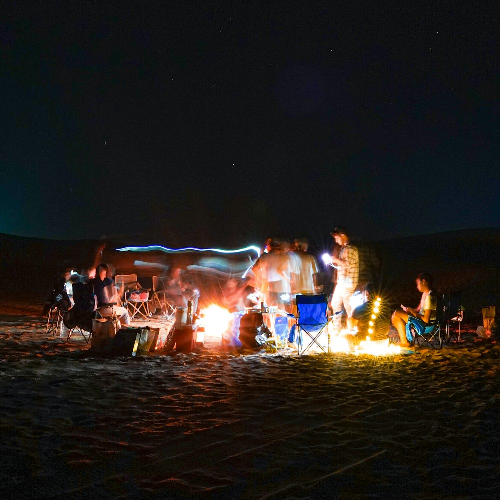 a group of people sitting around a campfire