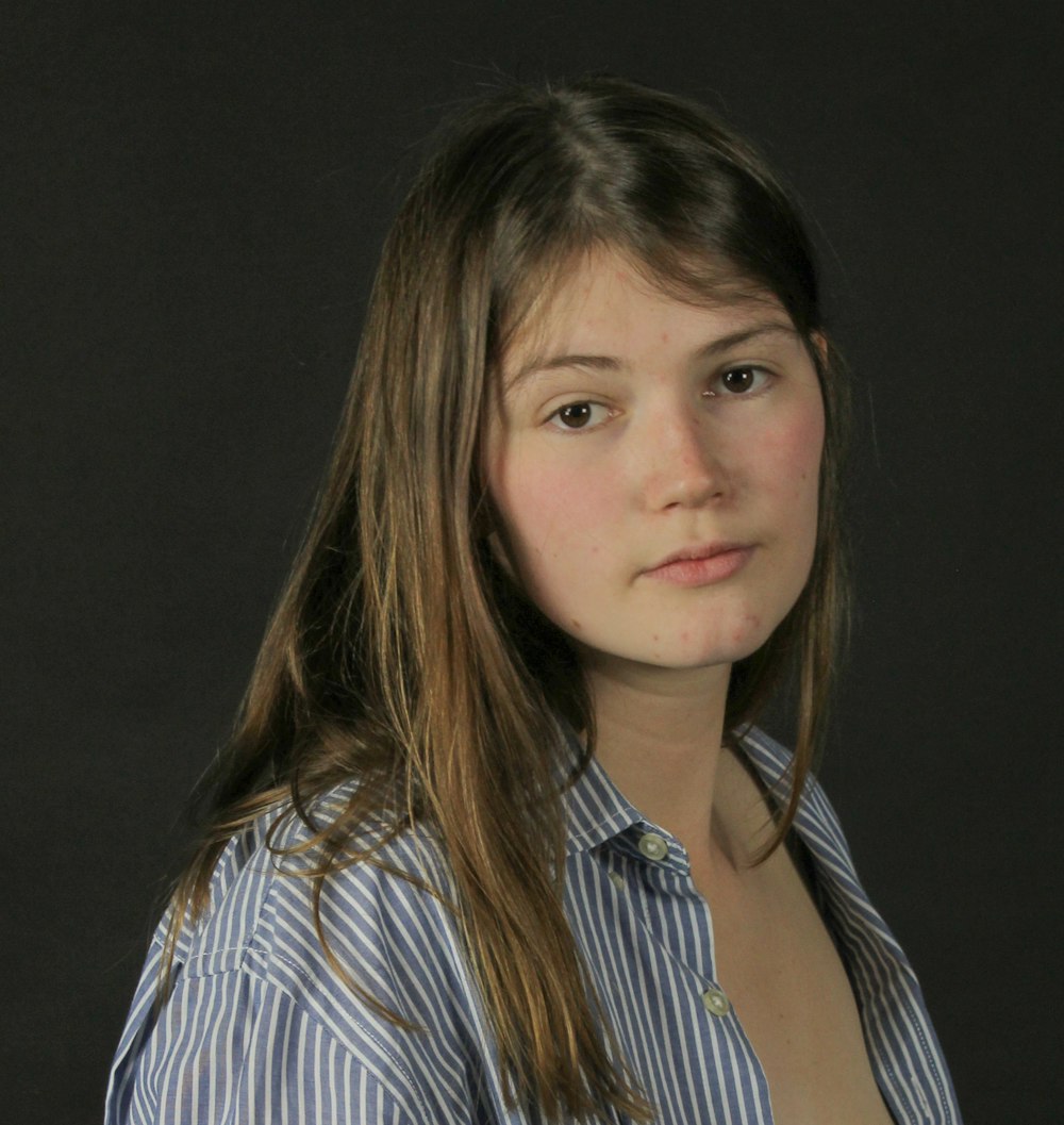 a woman in a blue shirt posing for a picture