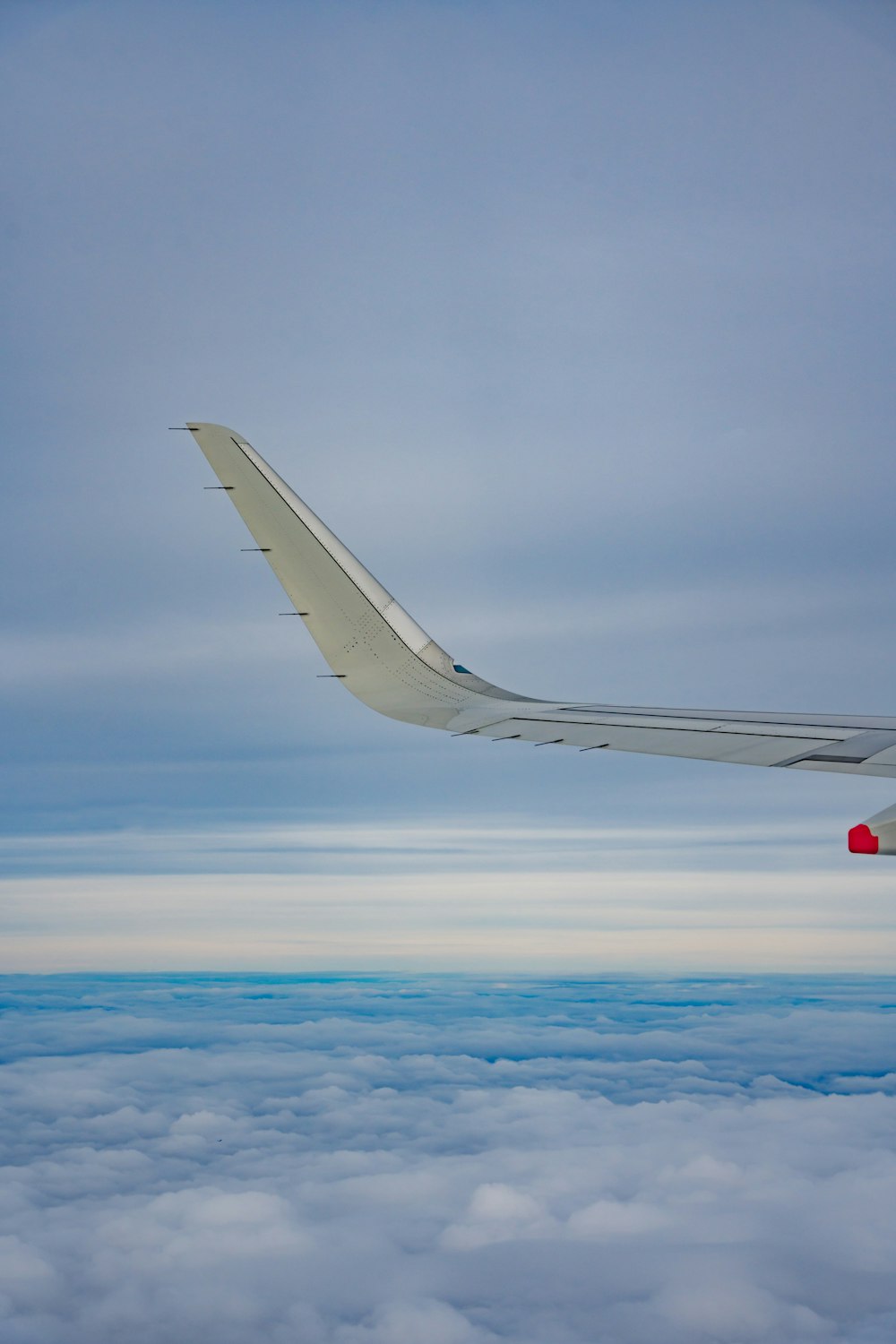 the wing of an airplane flying above the clouds