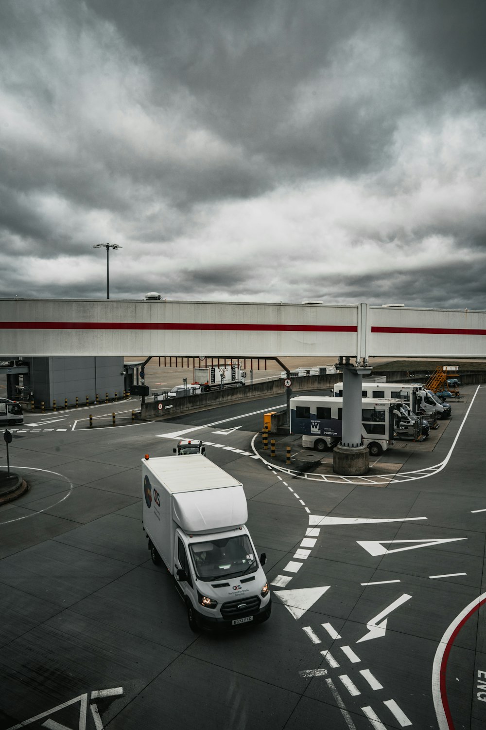 a white van driving down a street under a cloudy sky