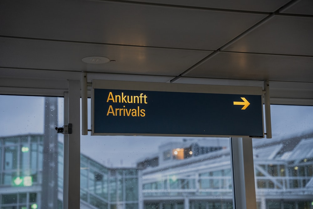 an airport sign hanging from the side of a building