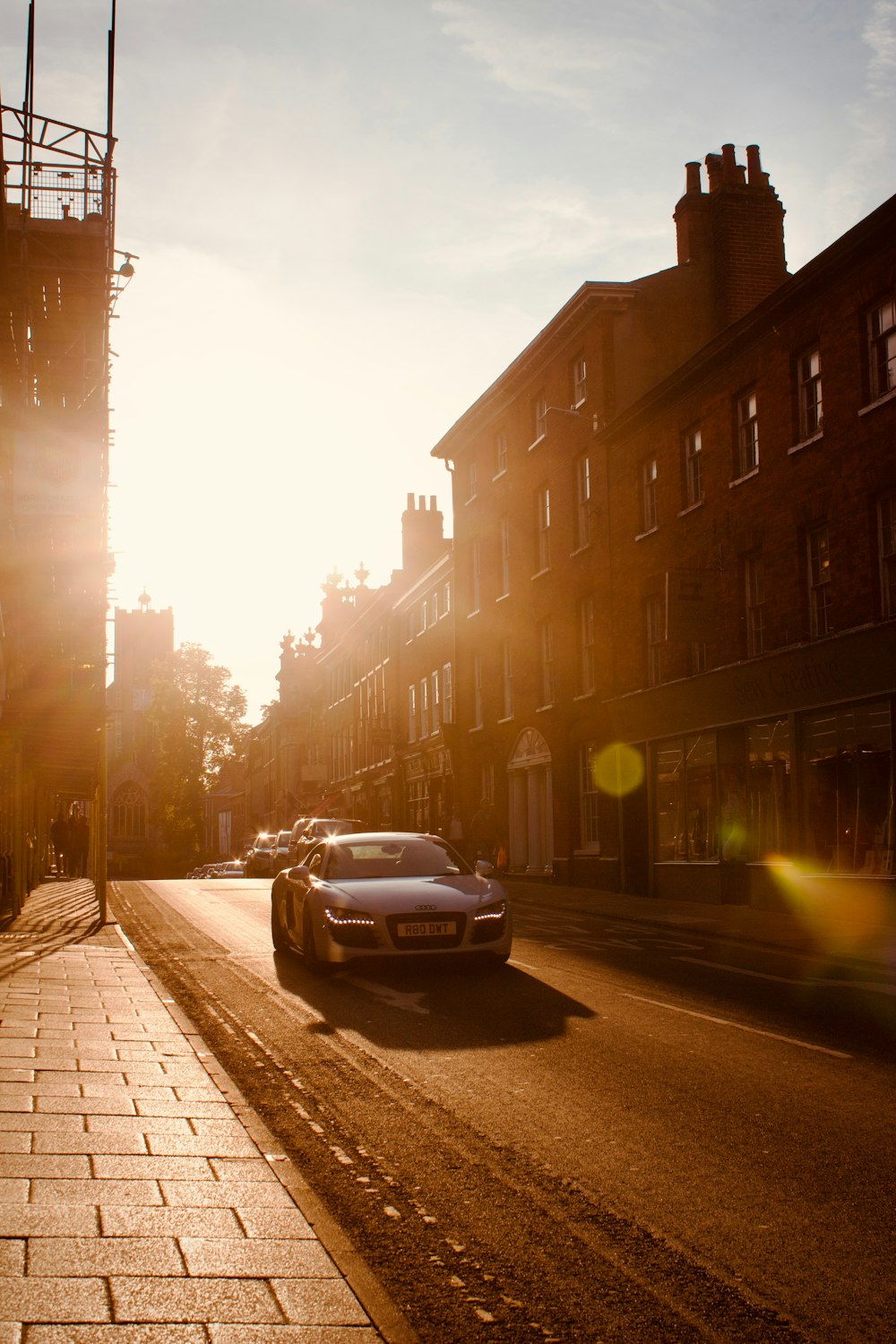 a car driving down a street next to tall buildings