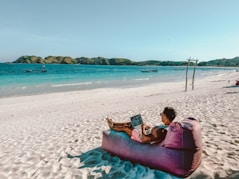 a man sitting on a bean bag on the beach