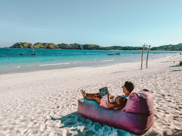 a man sitting on a bean bag on the beach