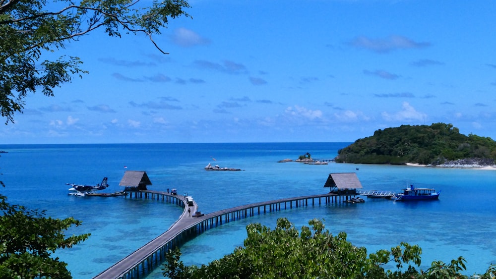 a pier leading to a small island in the middle of the ocean