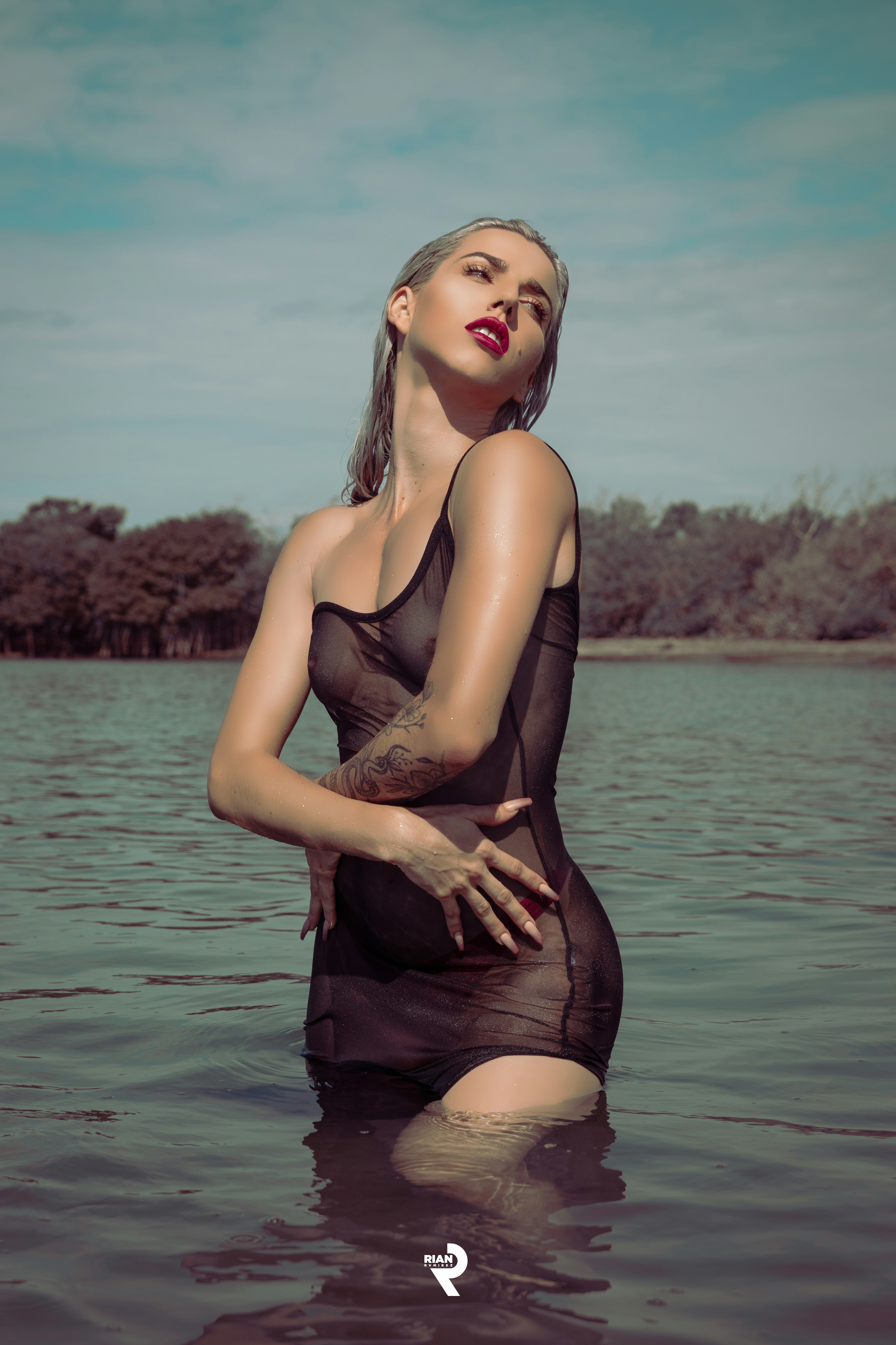 a woman in a body of water with her hands on her hips