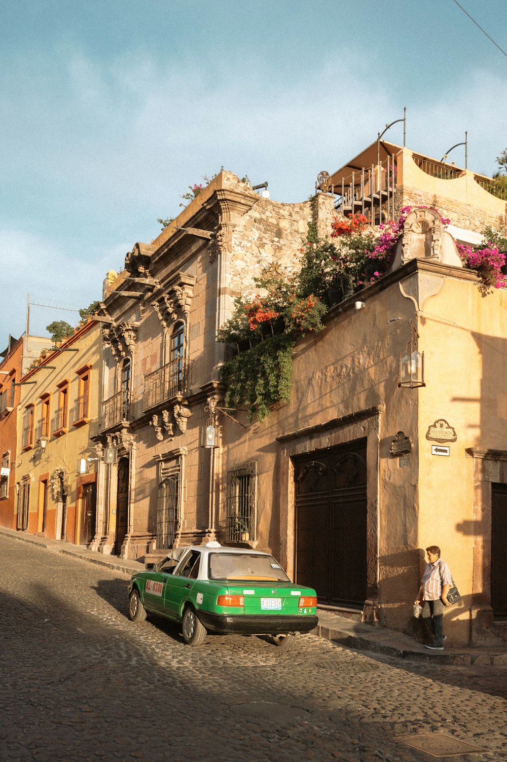 a green car parked in front of a building