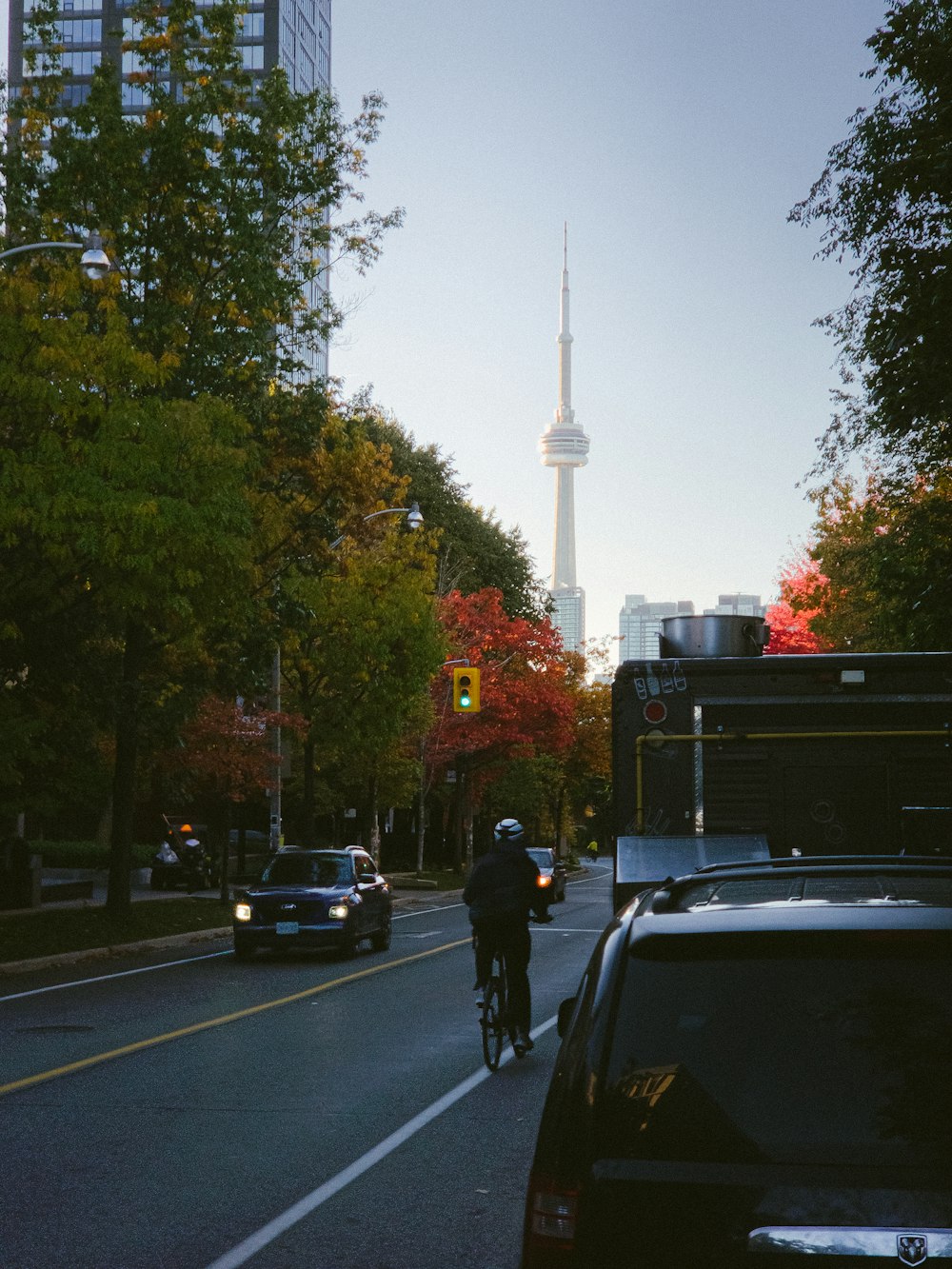 a man riding a bike down a street next to a traffic light