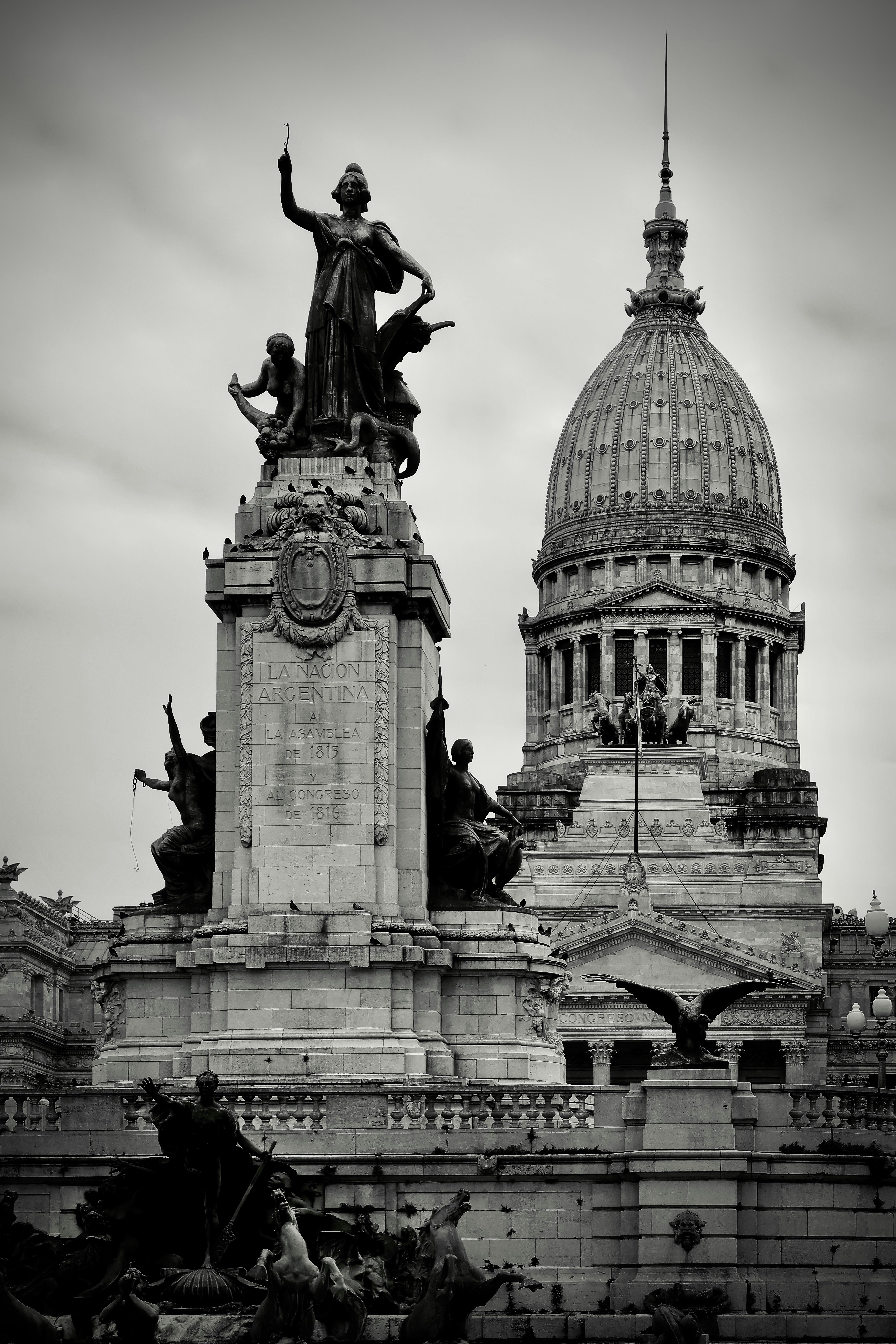 a black and white photo of a statue in front of a building