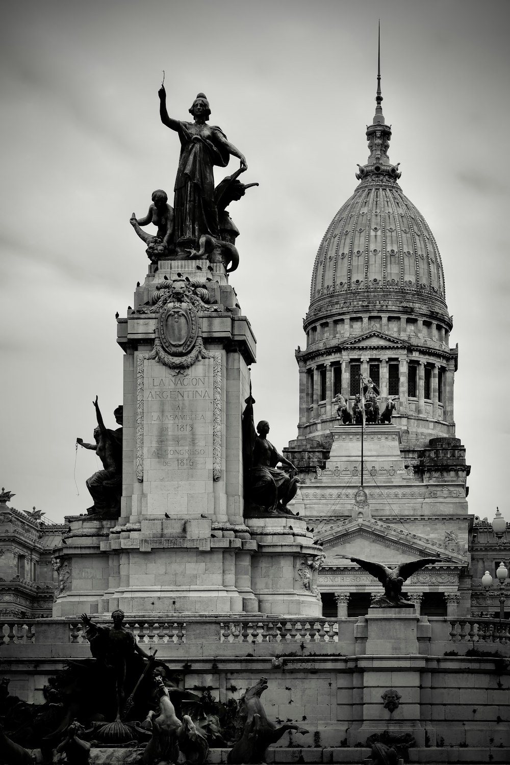 a black and white photo of a statue in front of a building