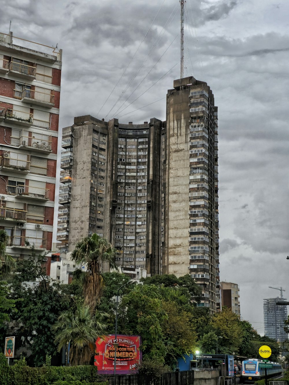 a very tall building sitting next to a lush green park