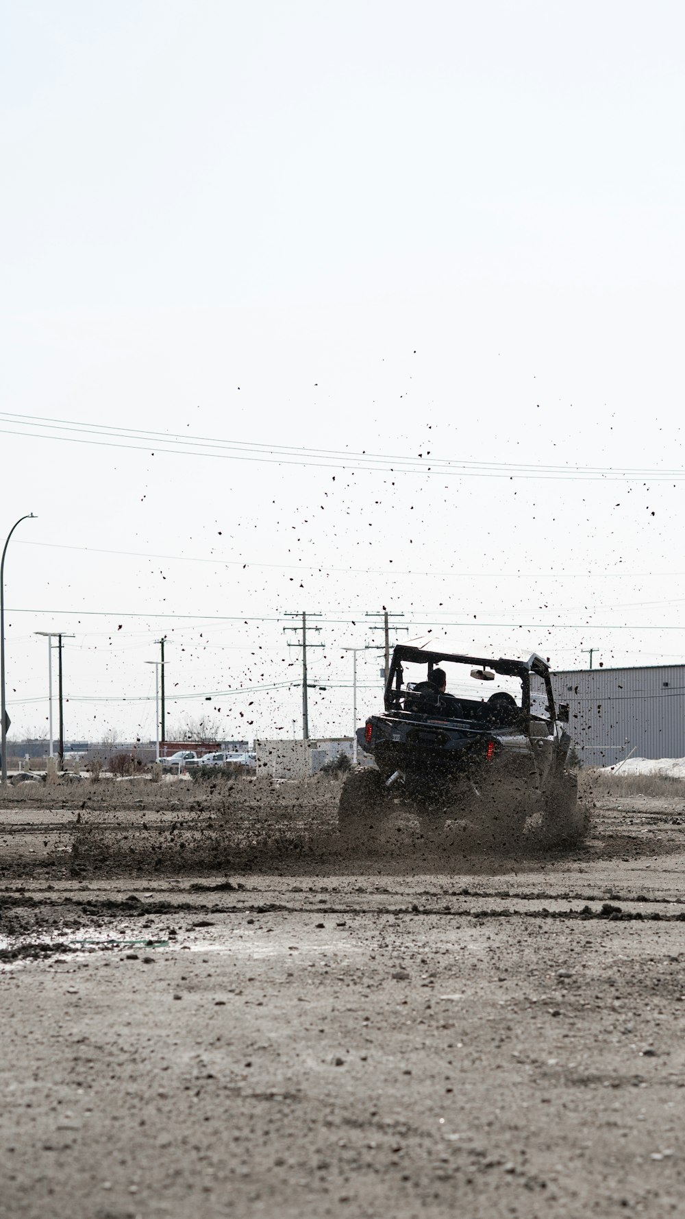a buggy driving through a dirt field next to a building