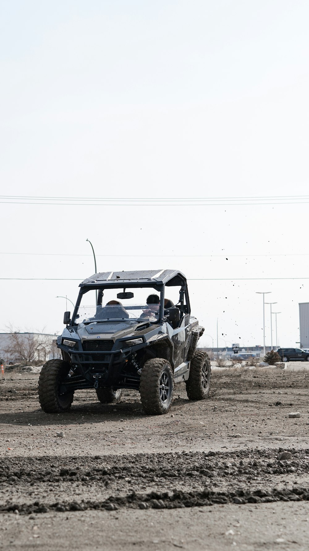 a man driving a four - wheeled vehicle on a dirt road