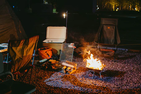 a camp site with a fire and a cooler