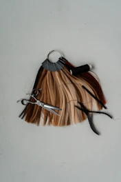 a pair of scissors sitting on top of a piece of hair