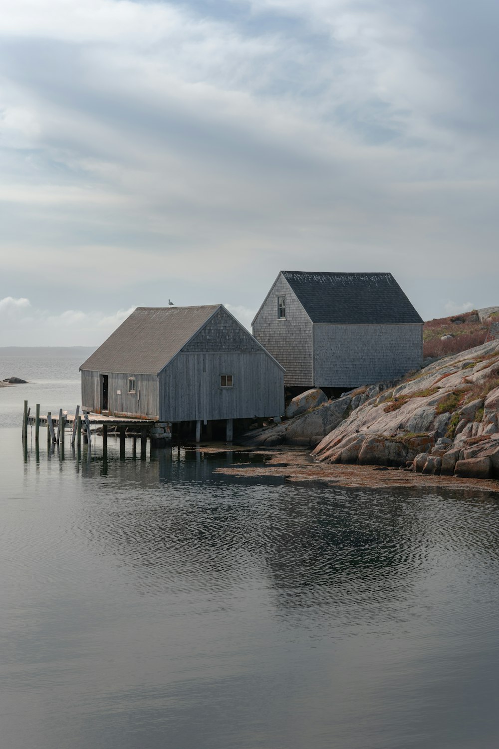 a couple of houses sitting on top of a body of water