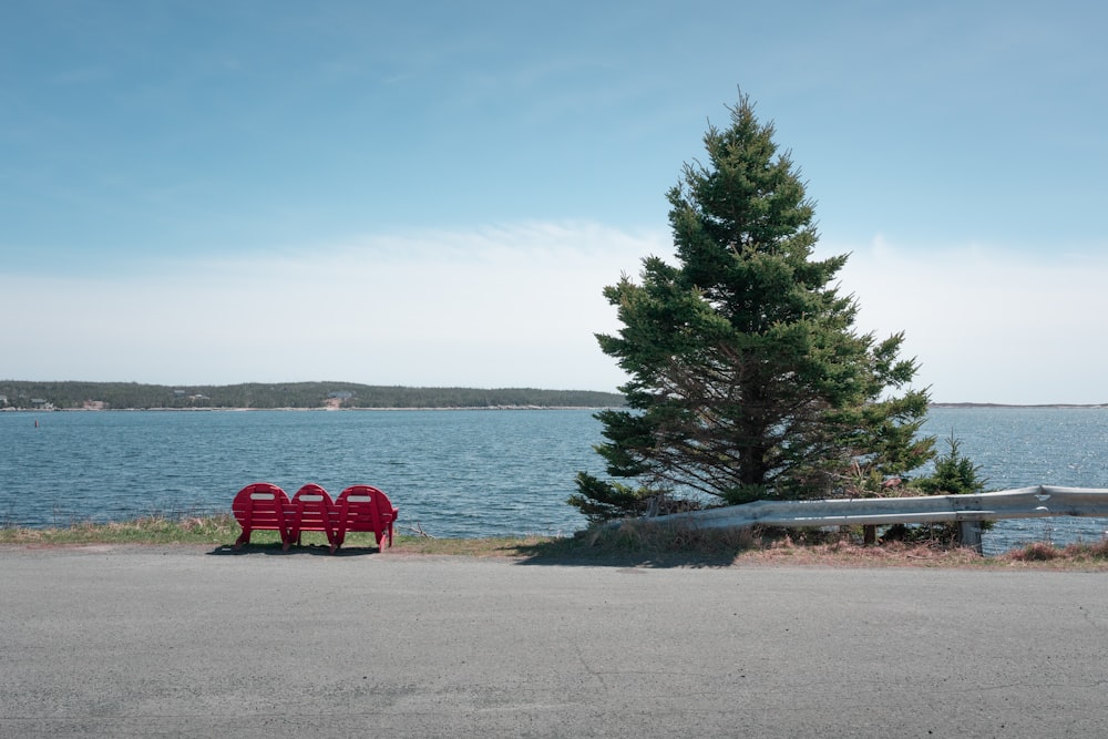 quelques bancs rouges assis sur le bord d’une route