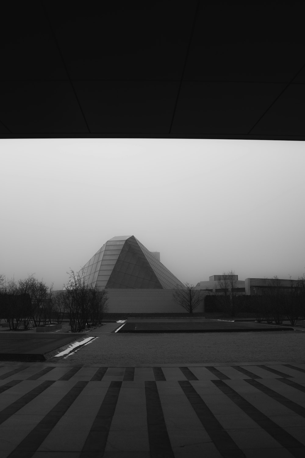 a black and white photo of a building in the fog