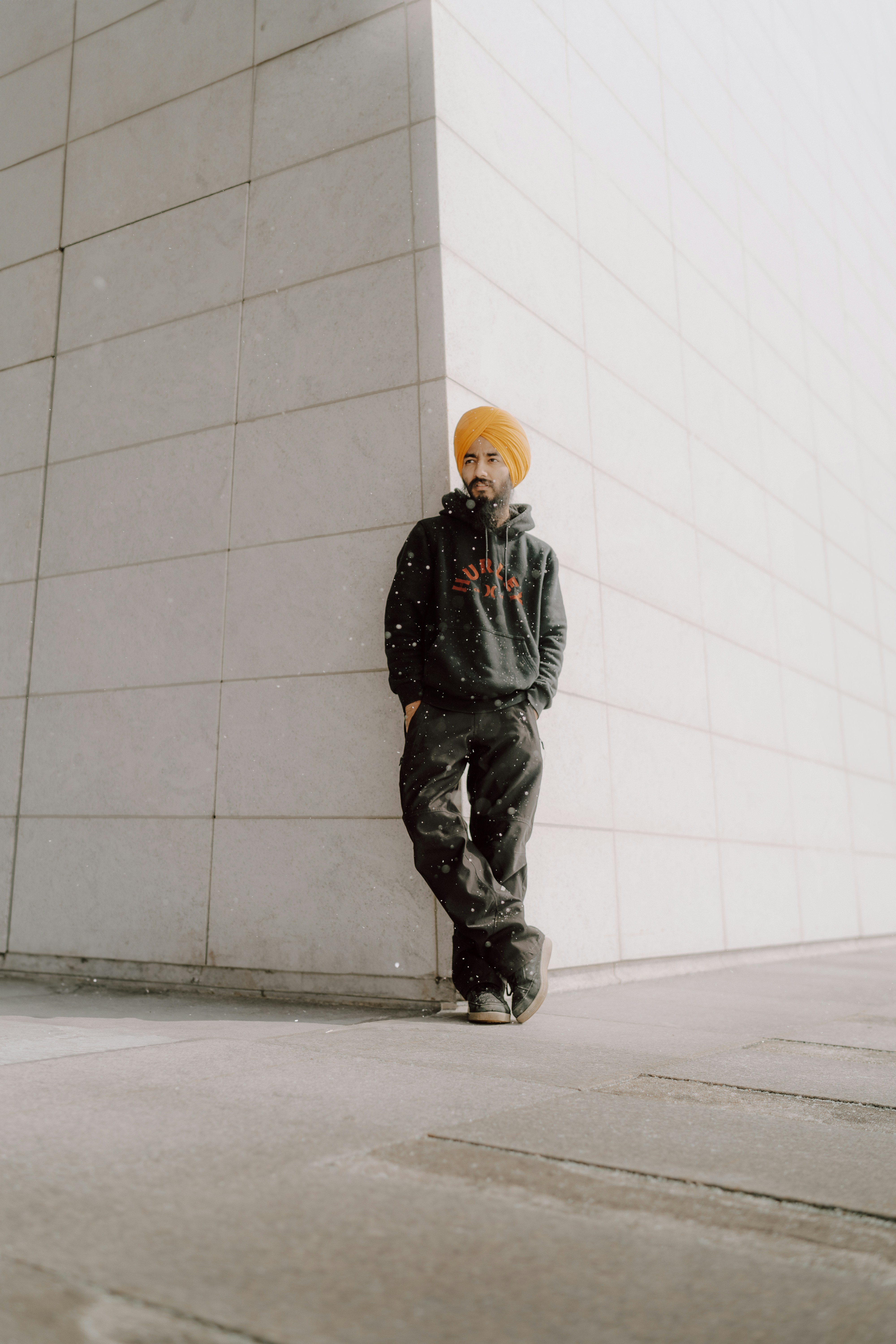 A man leaning against a wall wearing a yellow turban photo – Free Adult ...