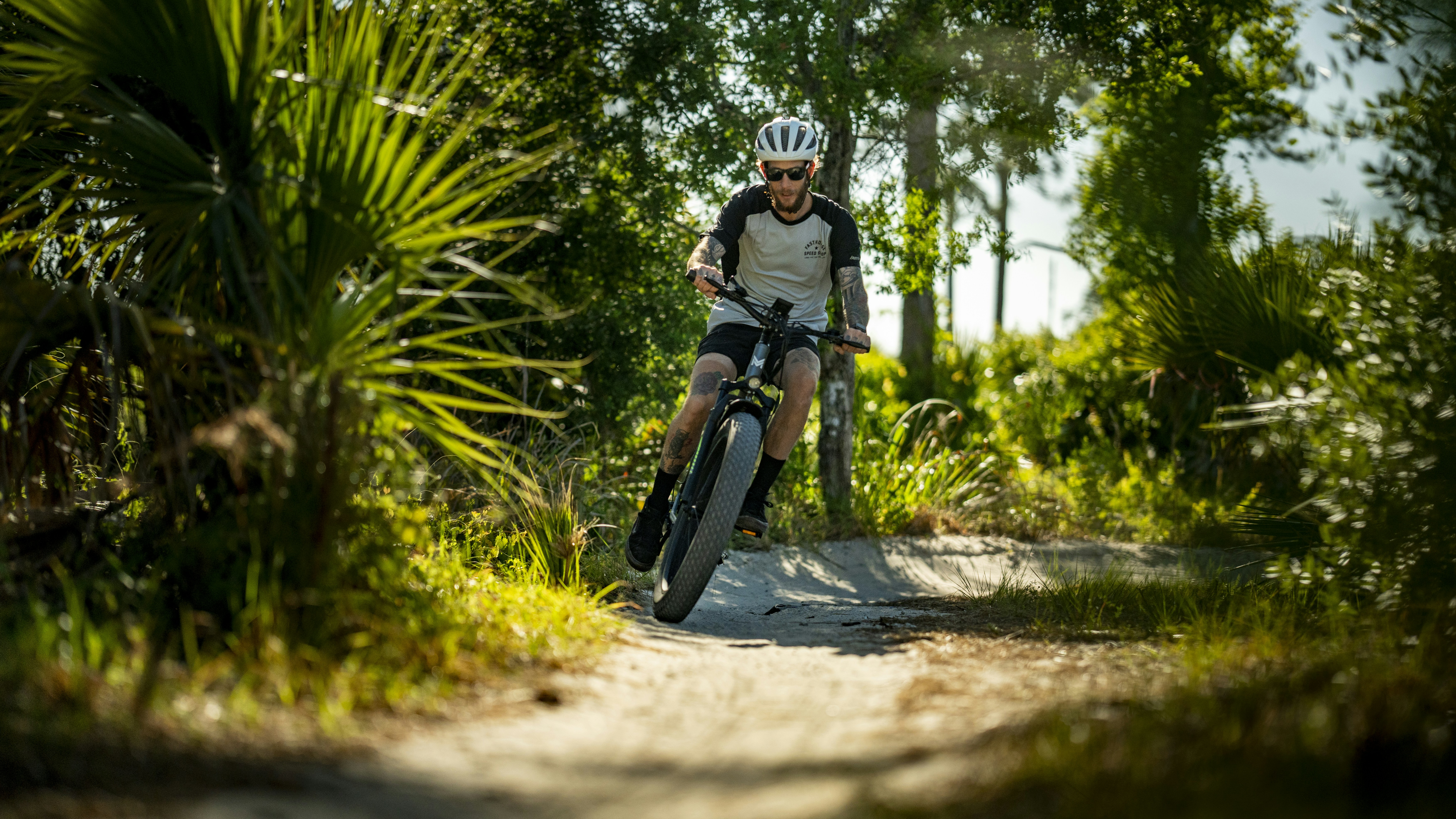 a man riding a bike down a dirt road