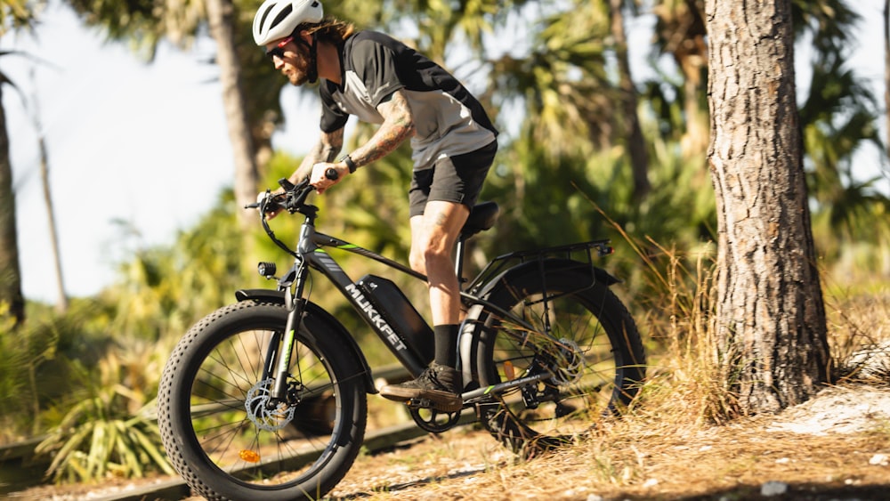 a man riding a bike through a forest